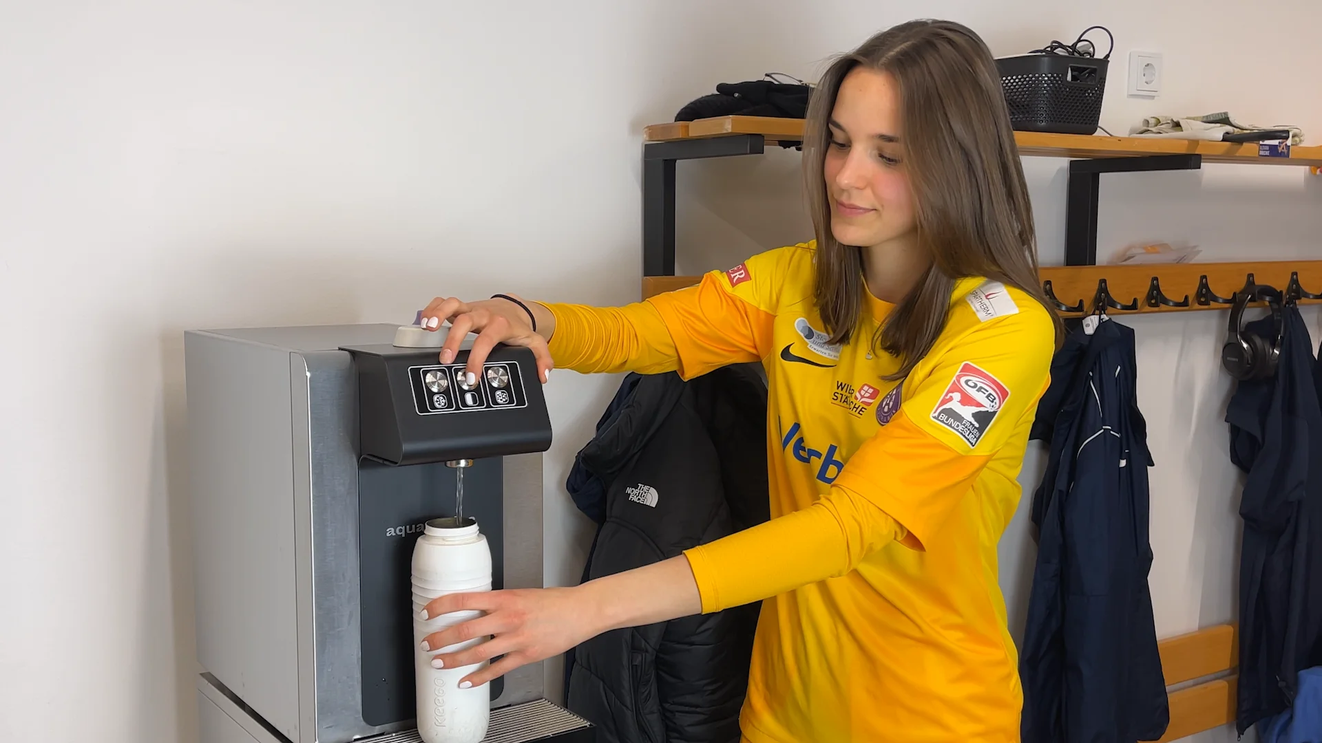 FK Austria Fußballerin holt Wasser von leitungsgebundenen Wasserspender