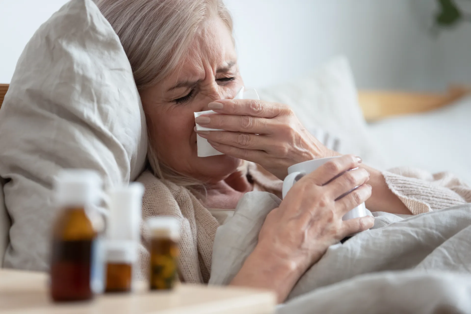 Kranke Frau die mit Grippe im Bett liegt