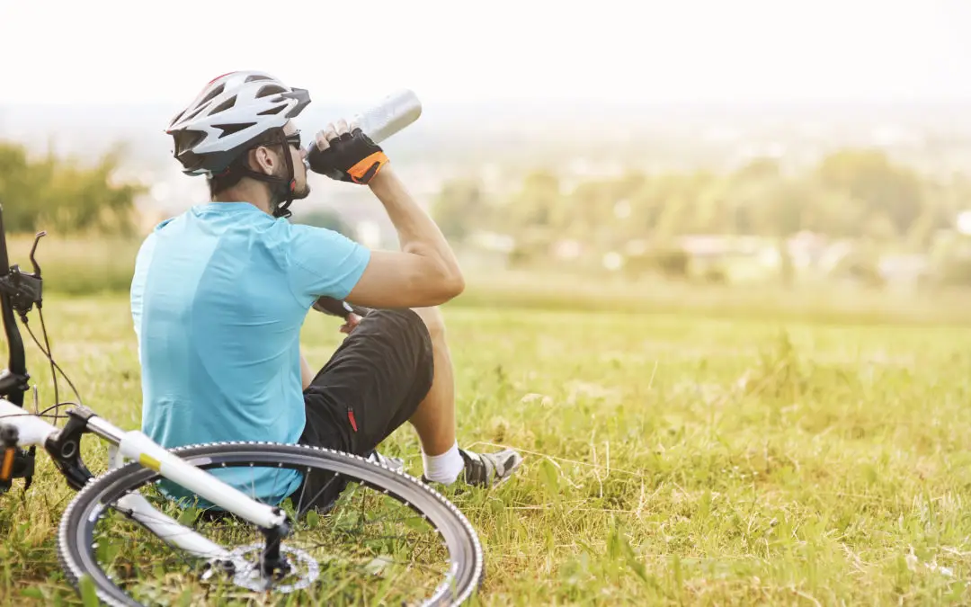 Mann trinkt Wasser aus Wasserflasche beim Fahrradfahren