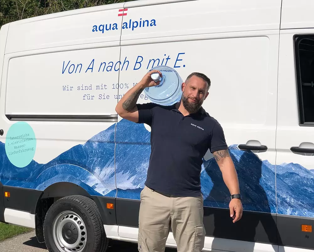 Servicefahrer-mit-wasserflasche-vor-auto